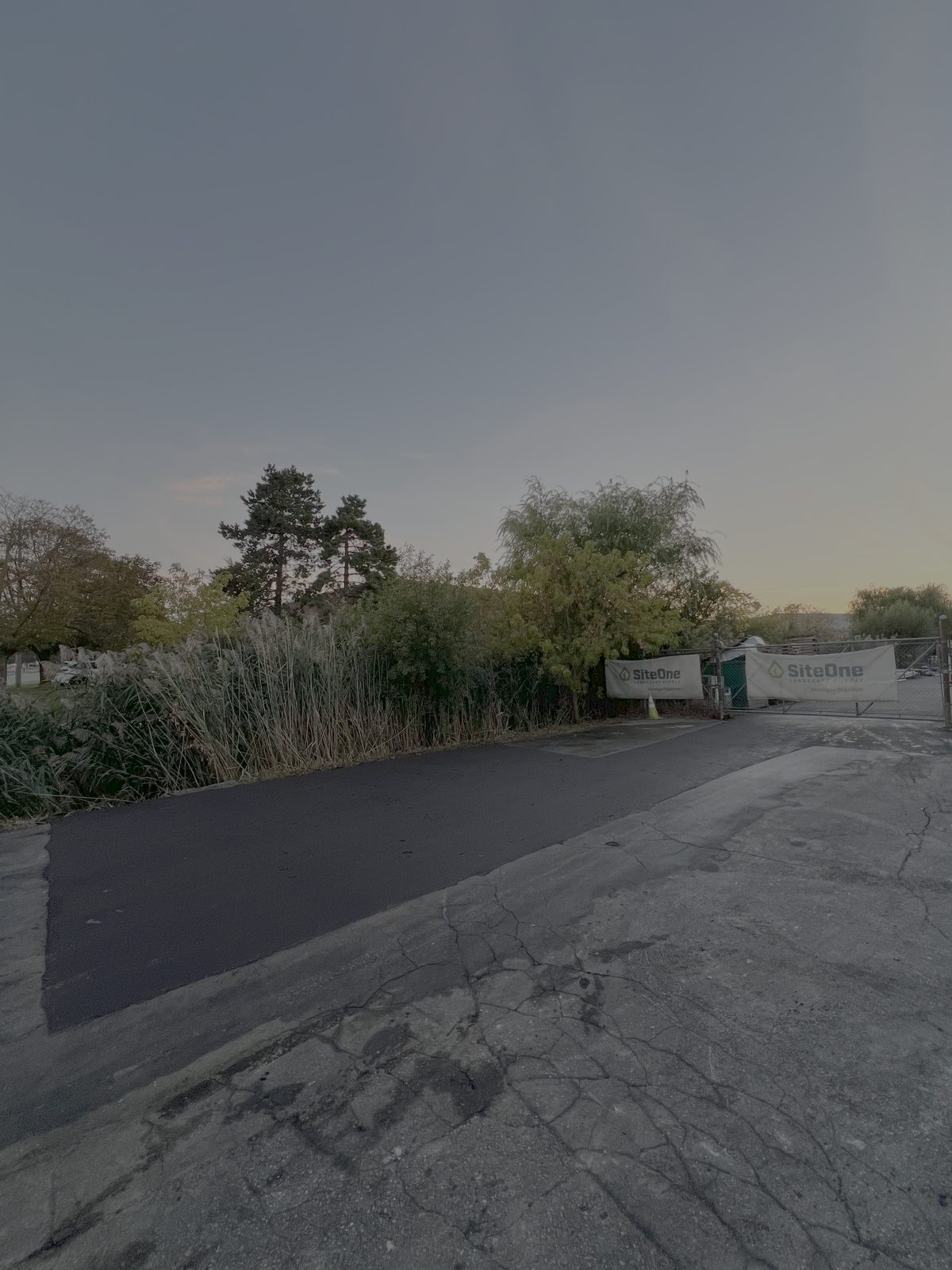 New asphalt patch repair next to aged cracked pavement in a GTA lot, showing fresh paving contrasted with worn surface